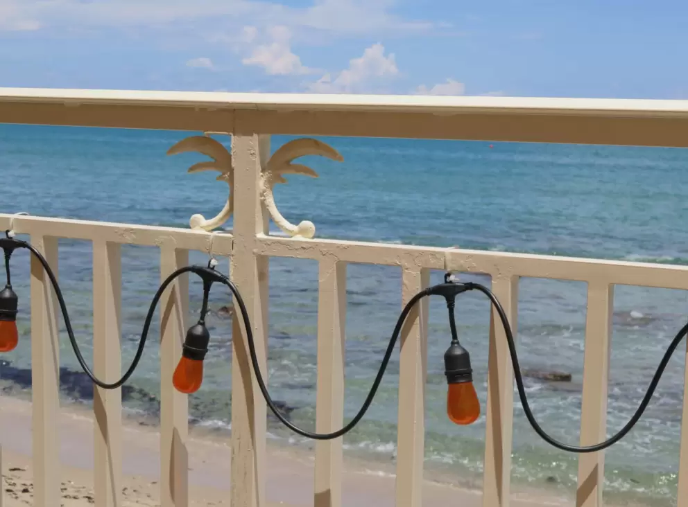 I love the strung lights and decorated white ironwork railing, with the color of the water behind. 