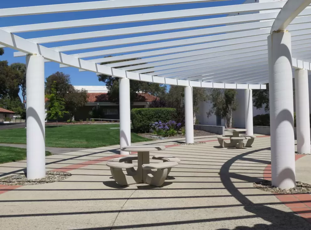 White trellis and picnic tables. 