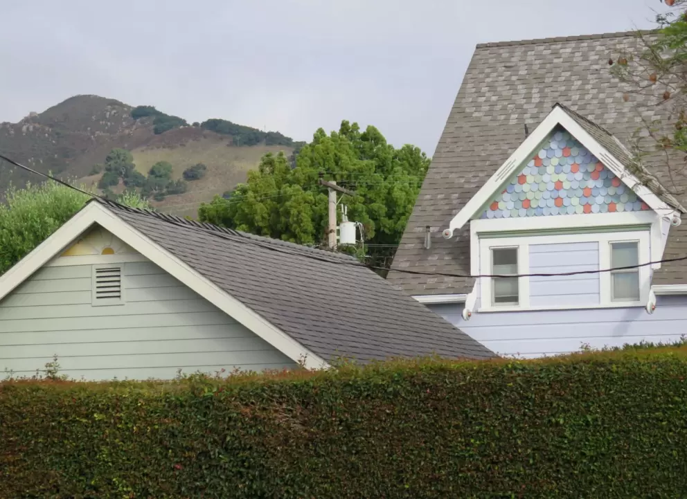 Round mixed-color shingles on a house gable. 