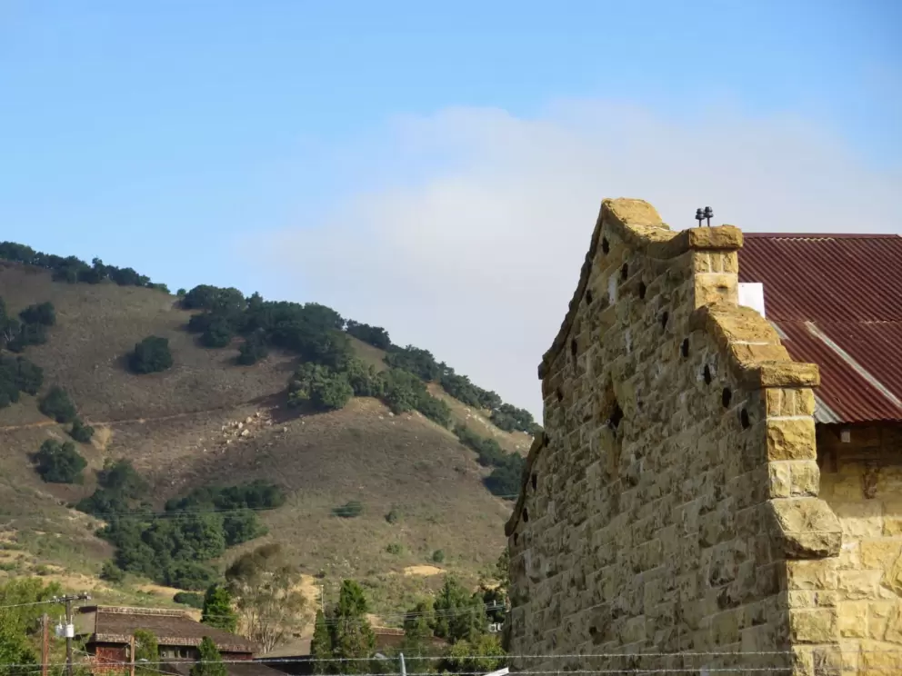 Old stone structure, with mountain behind, in the morning light. 