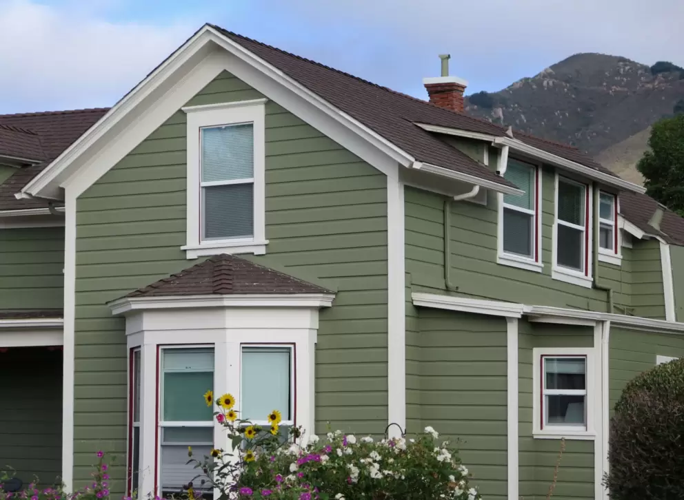 House with bay window, and mountain behind. 