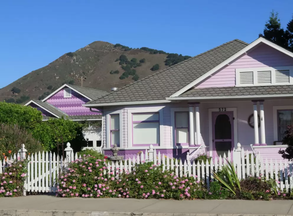 Pinks flowers on a white picket fence, pink shingles, and Cerro San Luis mountain!