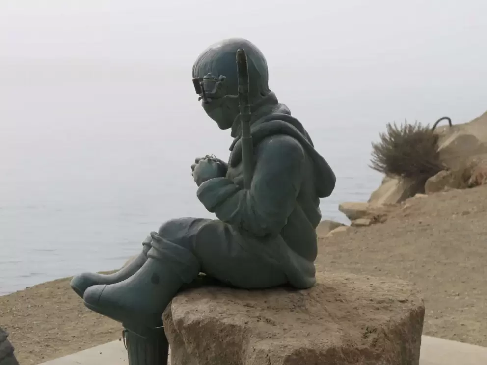 A sweet statue of a boy in boots with a fishing line. 