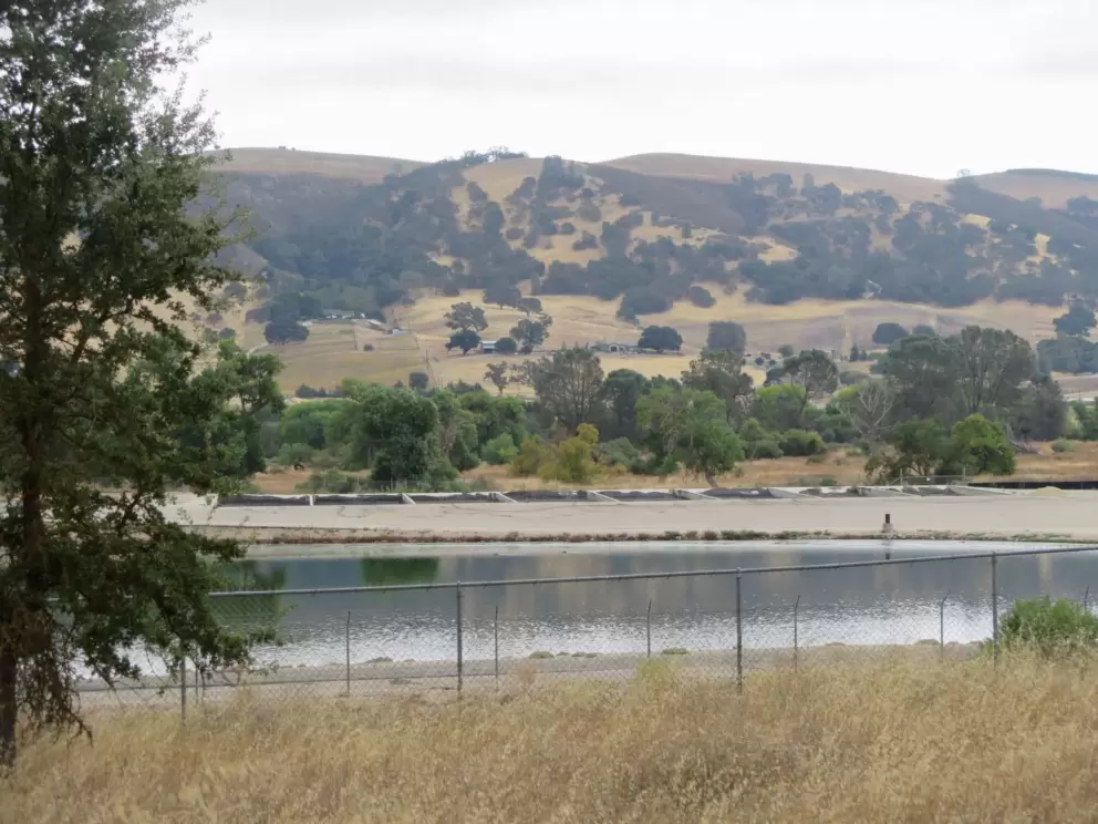 The sewer district water, and cute mountain behind. 