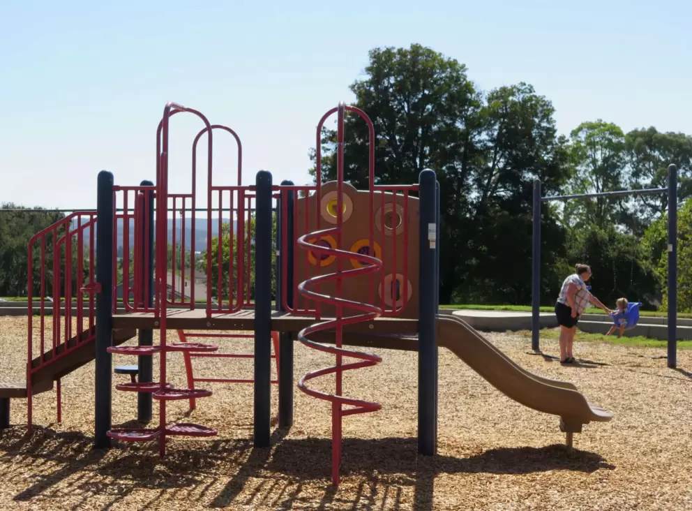 Toddler playground and a baby in a swing. 