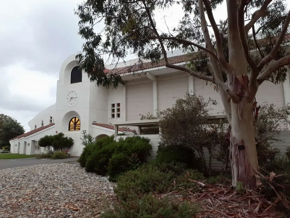 Pretty building with clock and arched window. 