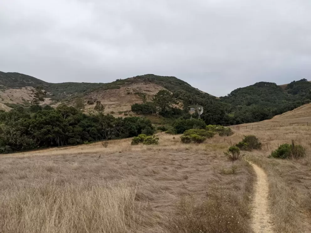 The trail winds through grasslands and past a windmill. 