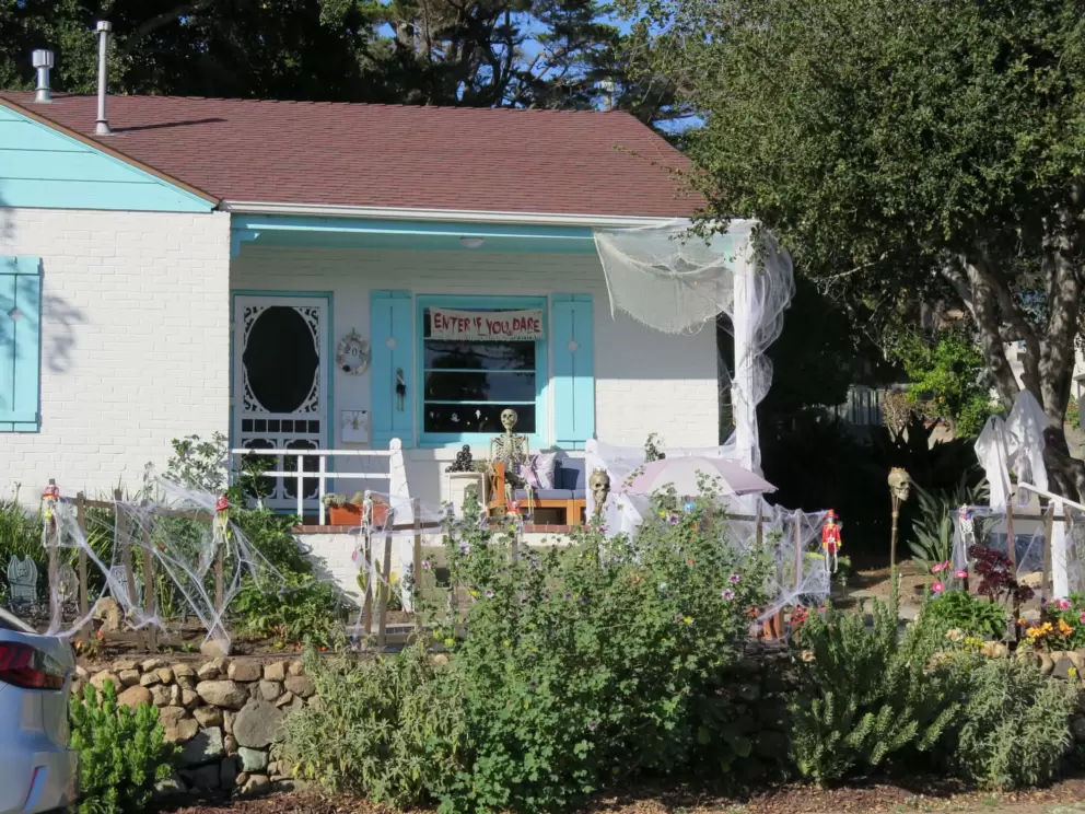 Halloween decorations at a house with Caribbean blue shutters. 