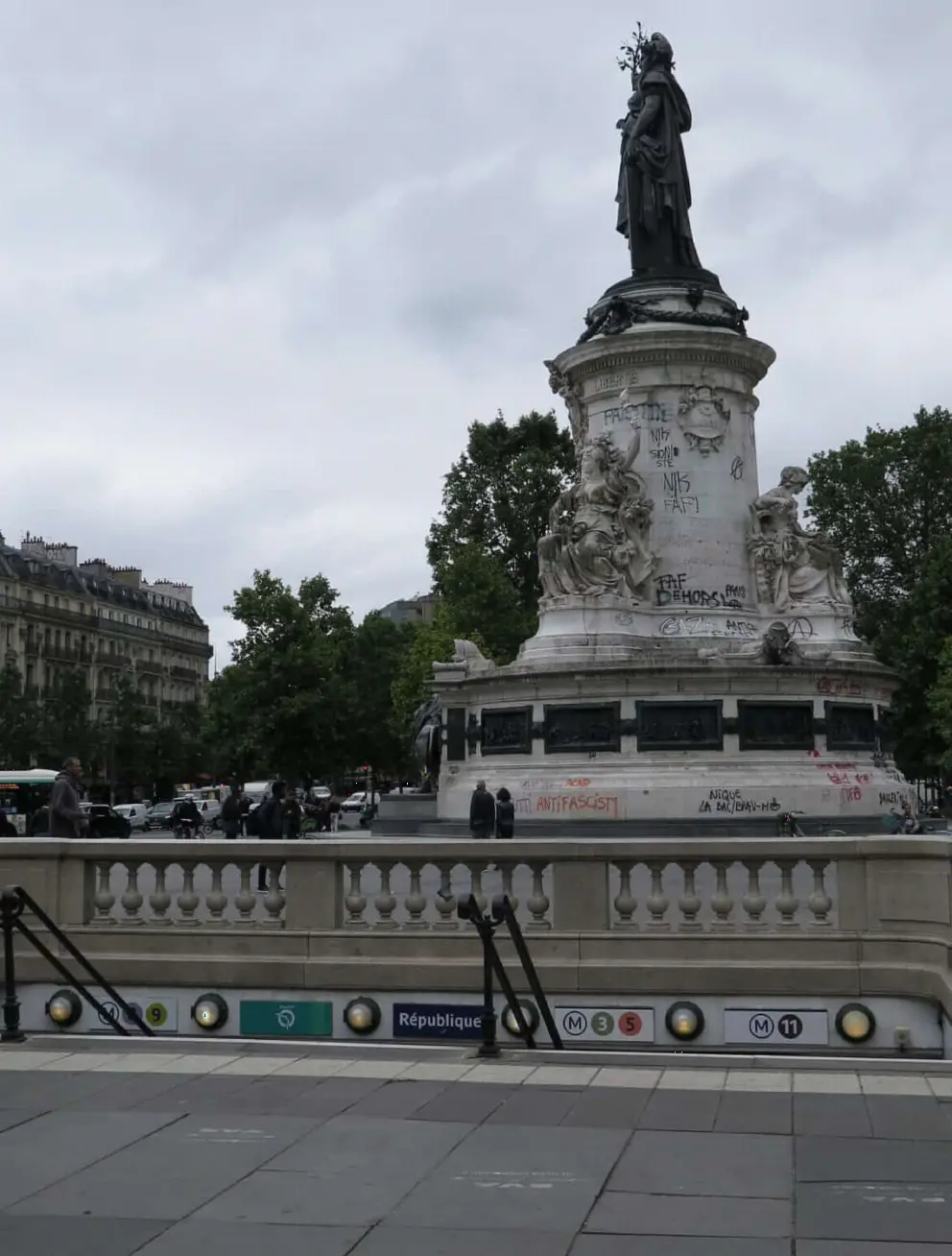 Political graffiti on the monument at Place de la Republique, by the metro station entrance. 