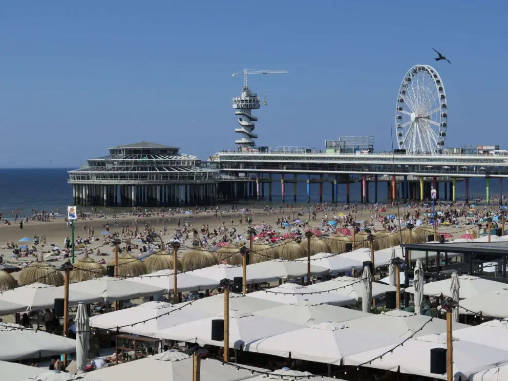 Looking down on the pop-up summertime cafes, crowded beach, and pier. 