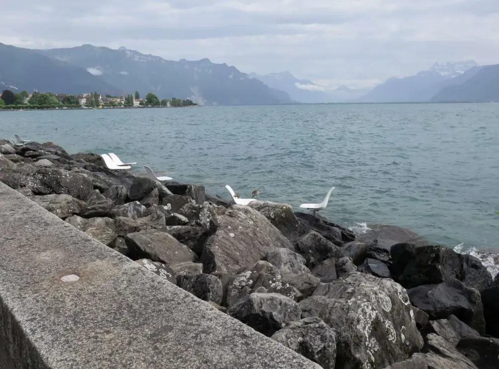 Chairs on the rocks by the water. 