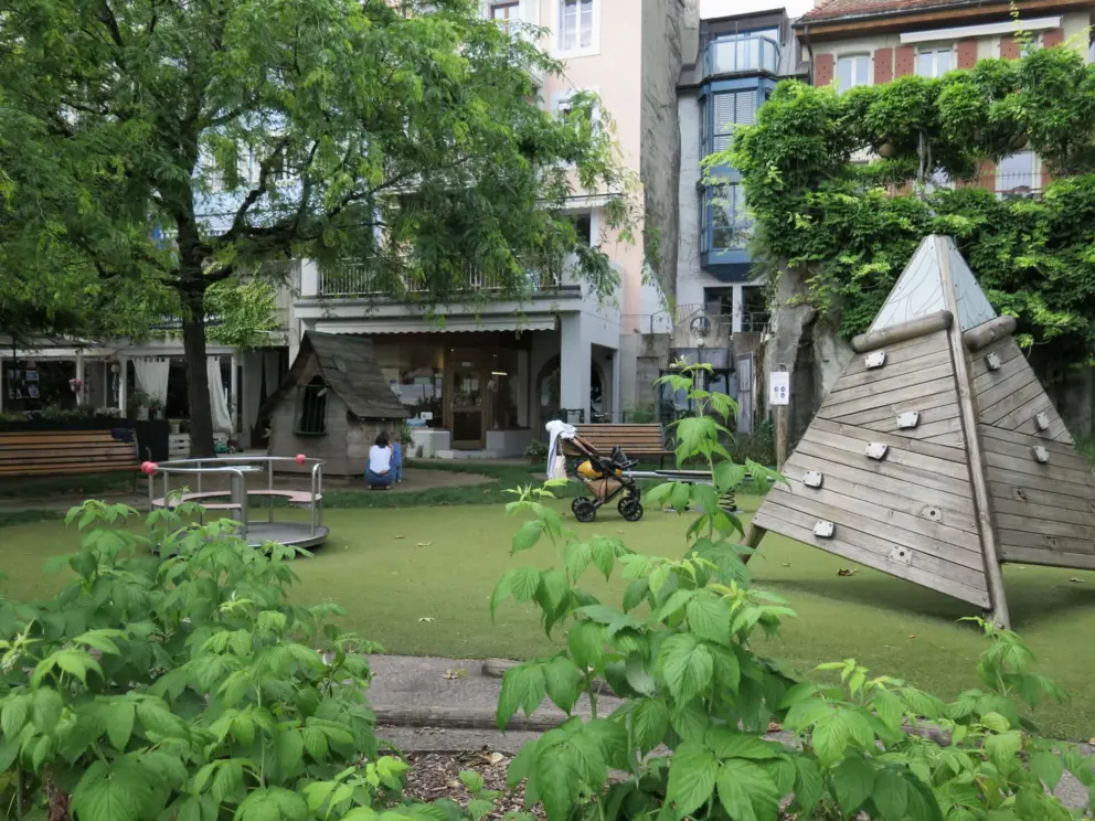 Playground along the walkway, with spinner, and wooden pyramid rock climbing for toddlers. 