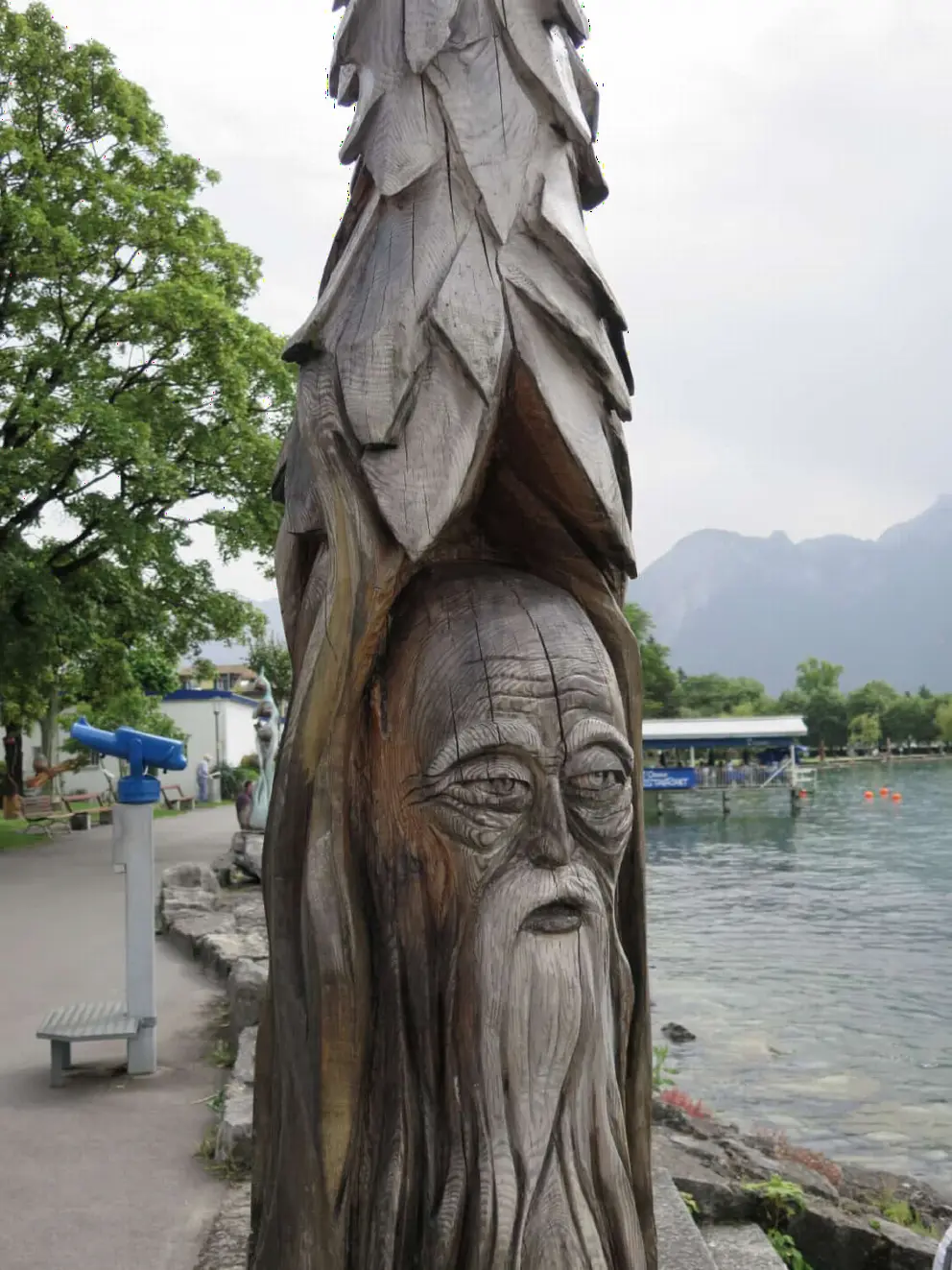 A wooden sculpture of a wise face. 