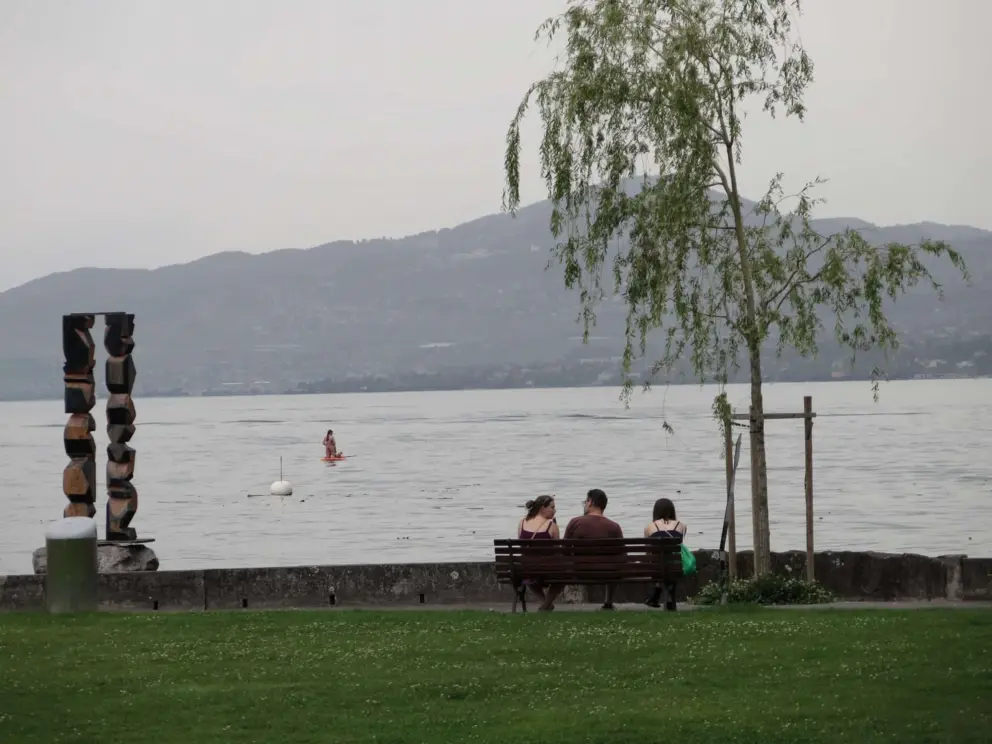 Sitting on a bench by the water. 