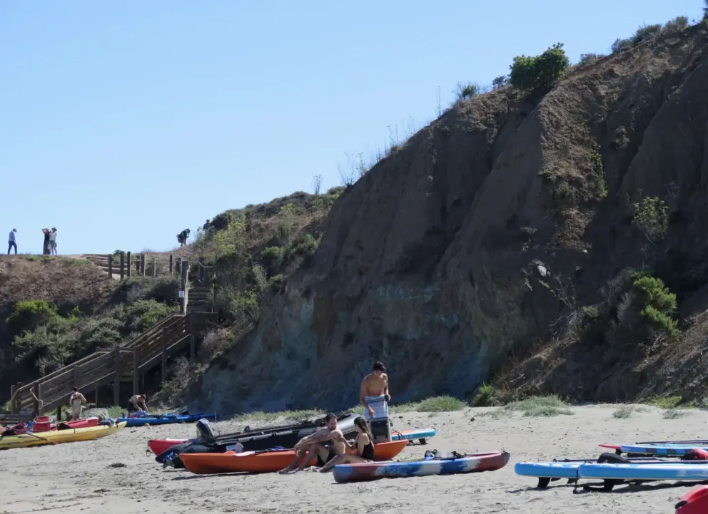 People standing atop the cliffs by the staircase. 