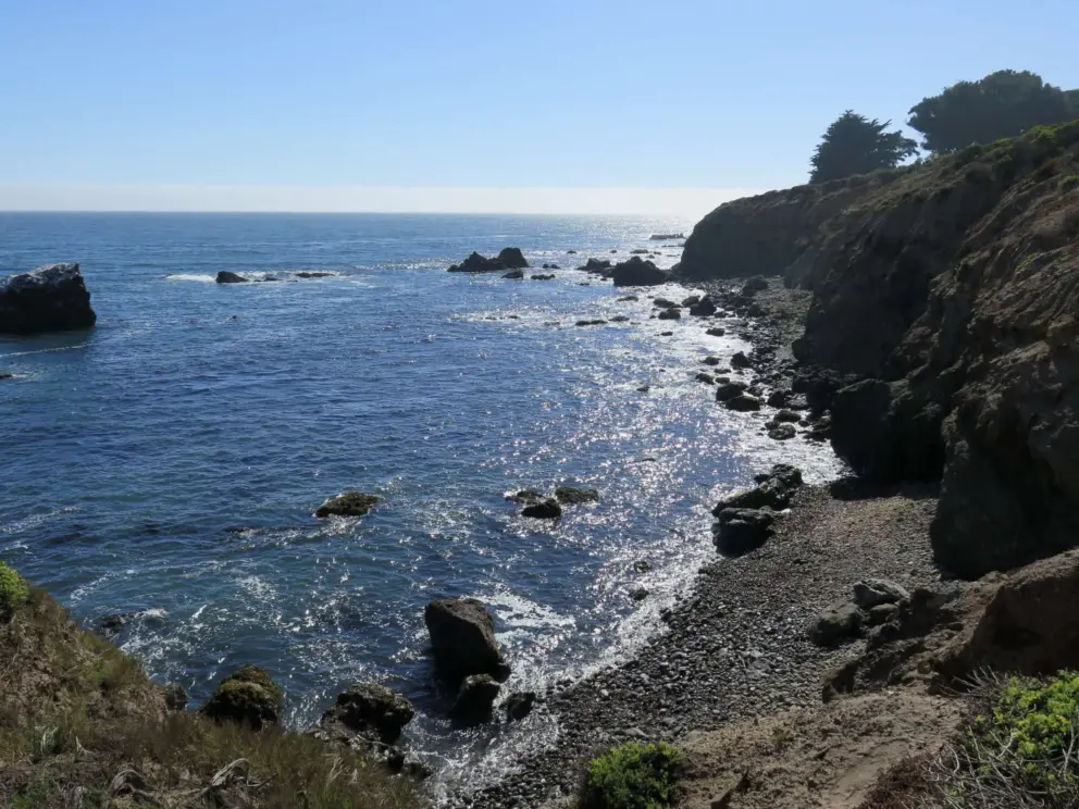 The rocky coastline, as seen from the path that leads down to the beach from the roundabout. 