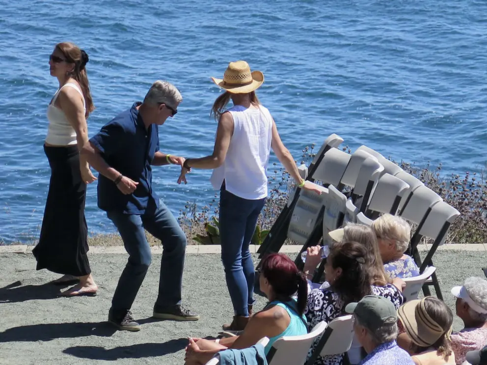 A couple grooves to the music, with views of the sea. 