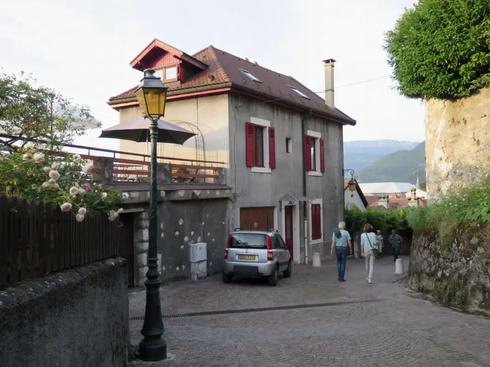 Lantern, roses, ivy, stone walls, and cobblestoned street, Rampe du Chateau. 