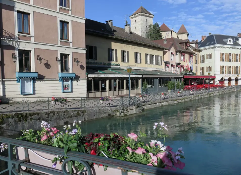Touristy cafes along the river, with the castle behind. 