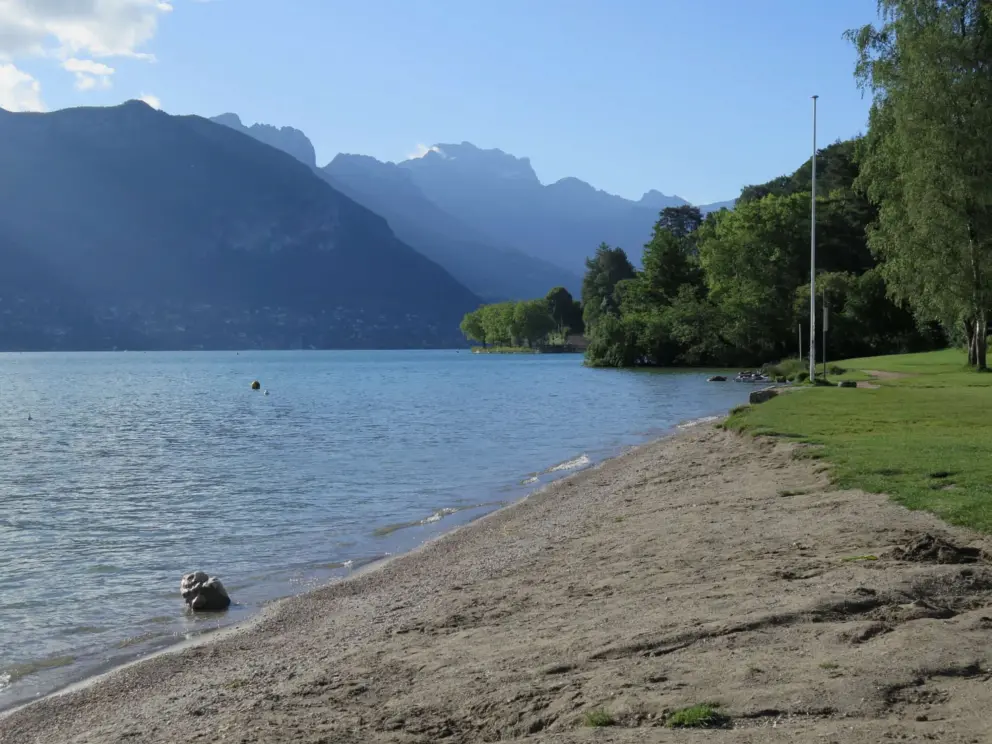 Sand and fine grass on the shore of the lake, at Plage des Marquisats. 
