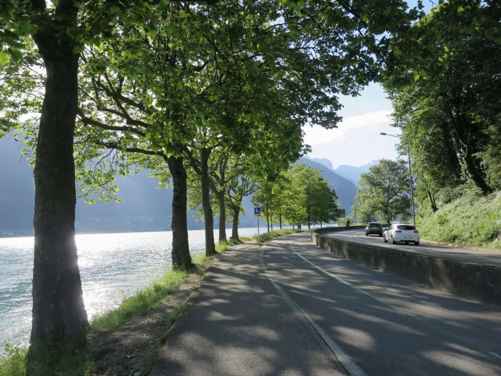 The walking path leaves the little beach park and then runs between a row of trees and Rue des Marquisats. 