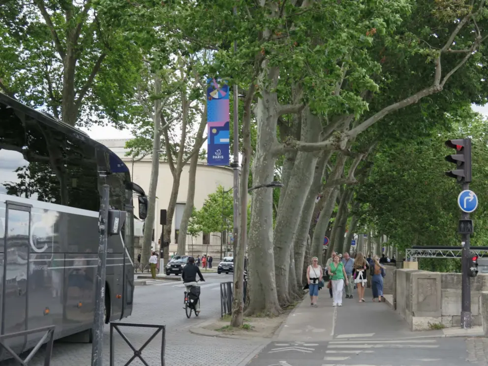 The walkway above Port Debilly is crowded, and noisy from traffic.