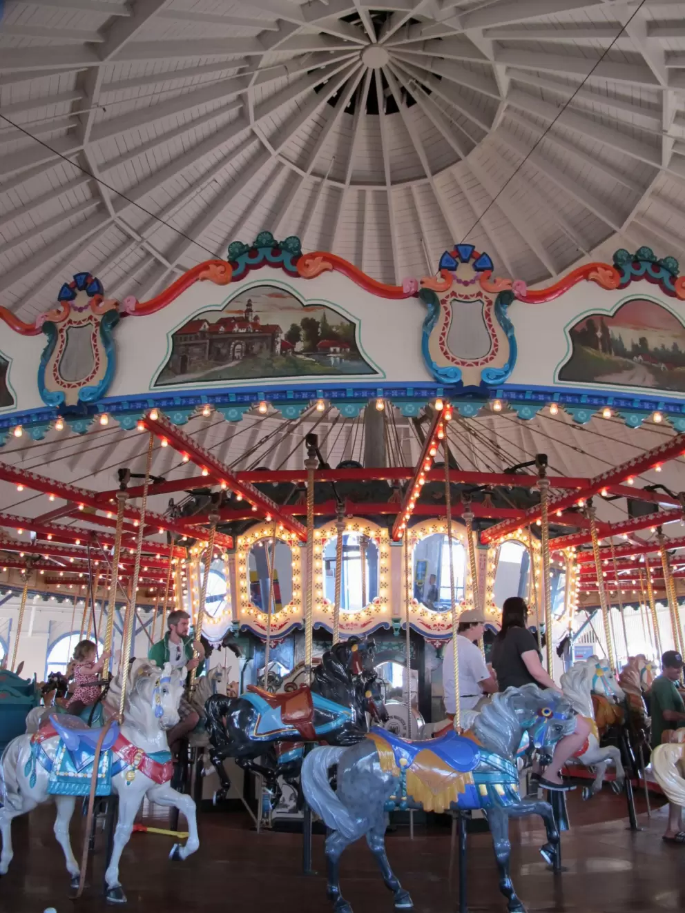 The pale blue carousel, indoors on the pier.
