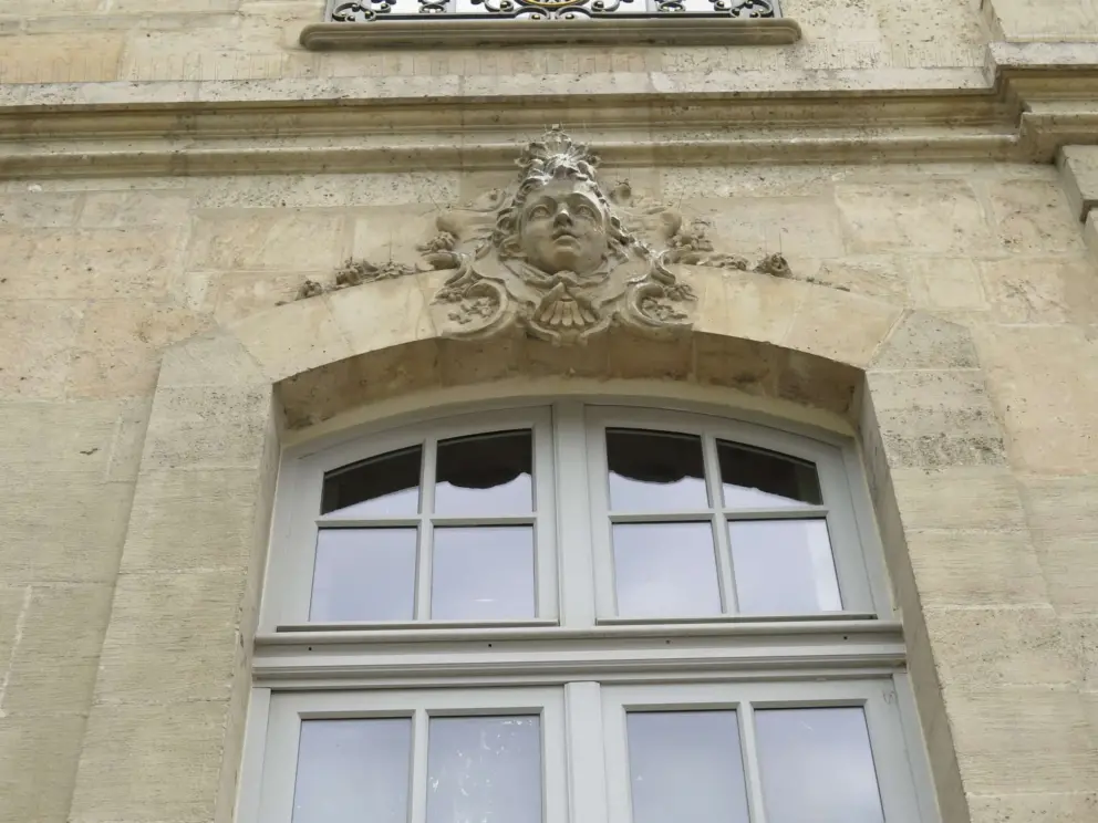 Sculpted head above a mansion window. 