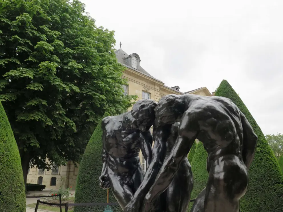 Sculpture of three males in the topiary garden. 
