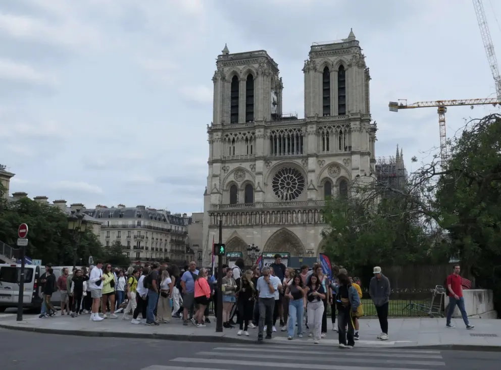 Tourists watching the construction outside Notre Dame Cathedral in June 2024. 