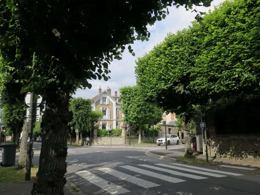 A cute house, stone fences, and tree-lined streets. 