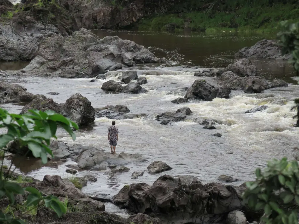 A man stands by the stream, which is not a very safe area. 