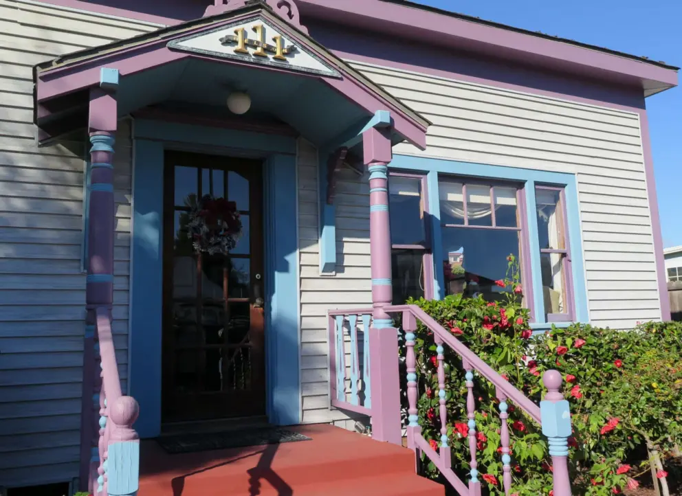A historic house with blue and purple banister. 