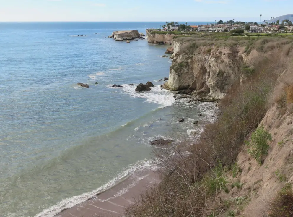 Views of the blue-green water and cliffs, from the sidewalk on Price Street. 