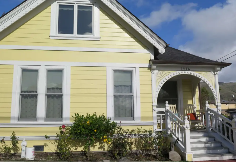 Yellow house with arched entry patio. 