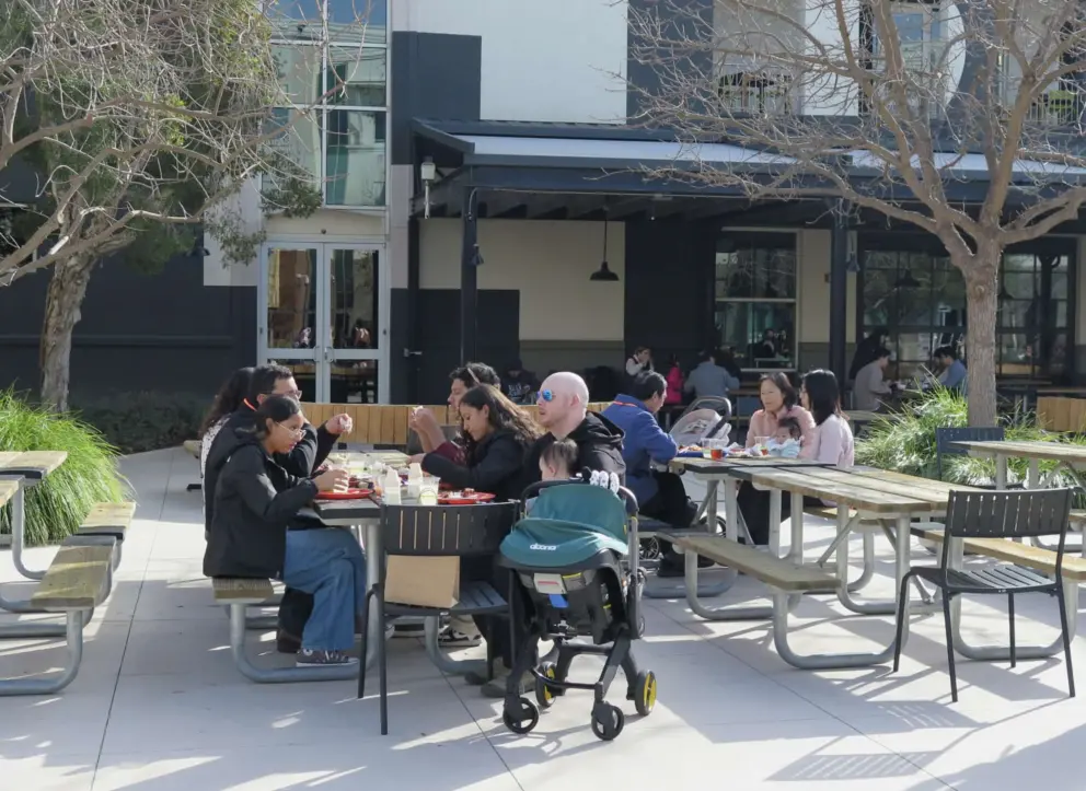 A family eats outside the breakfast hall. 