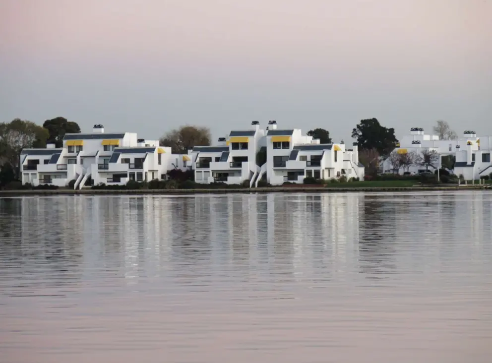 The condos across the water have yellow awnings. 