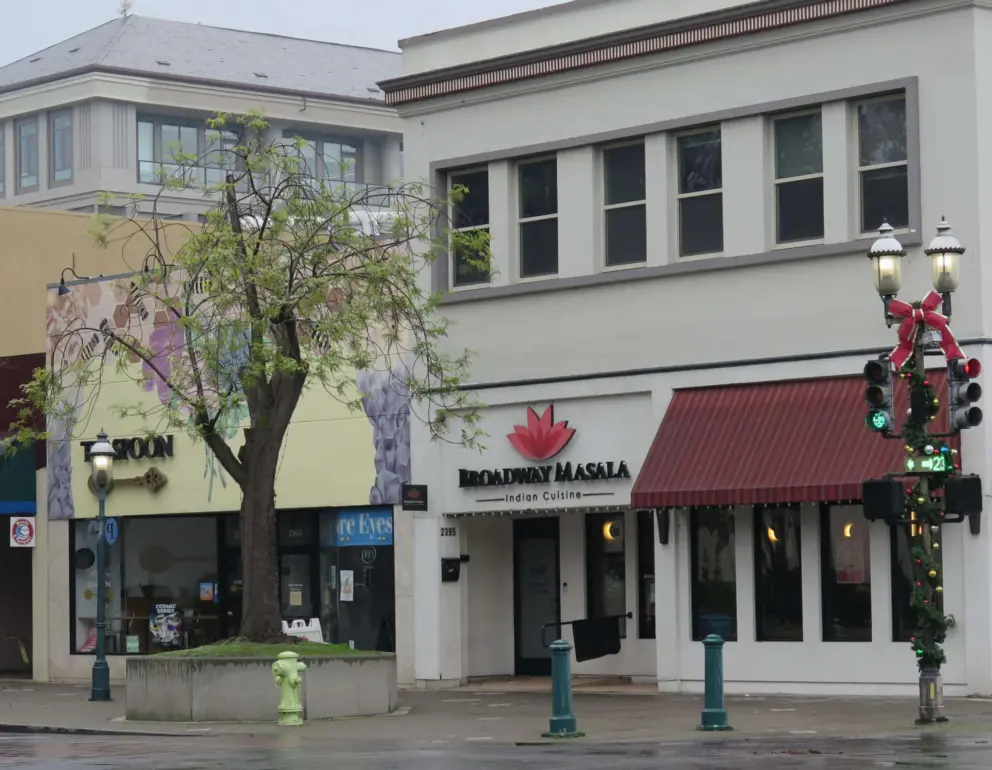 Indian restaurant and boba tea place on Broadway, with Christmas decorations on the lamppost. 