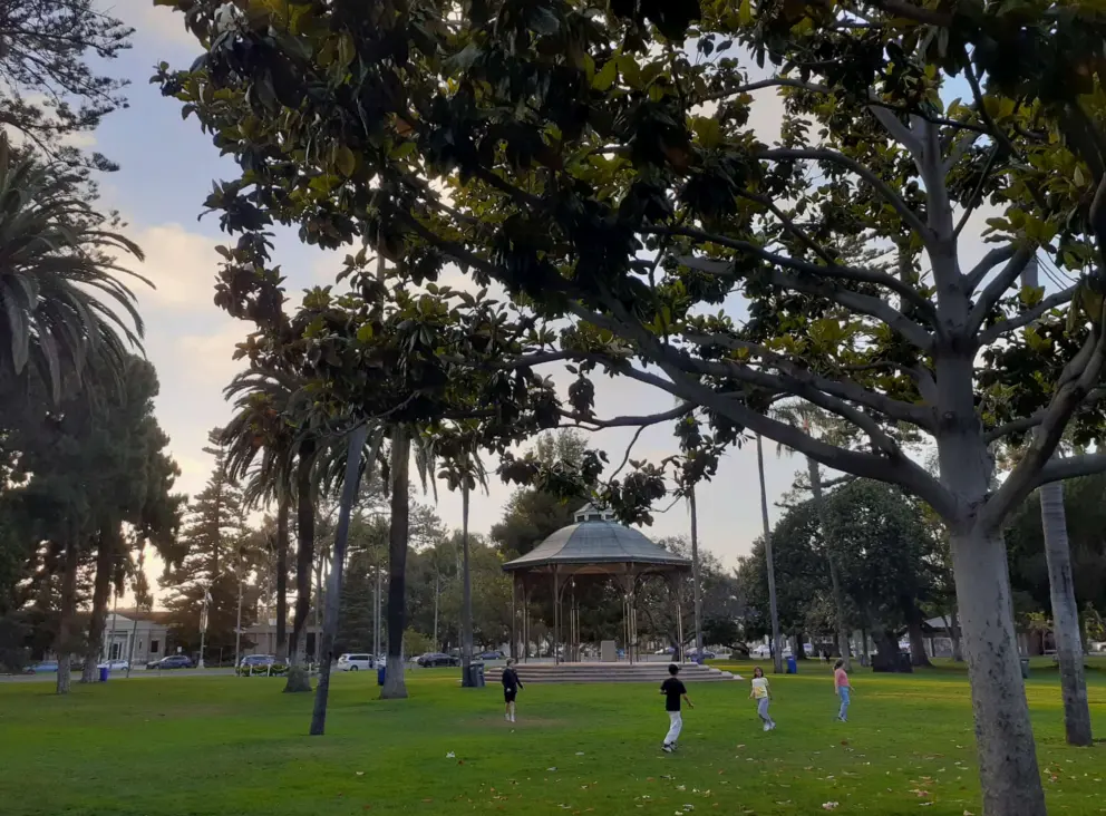 Kids play on the lawn by the gazebo.