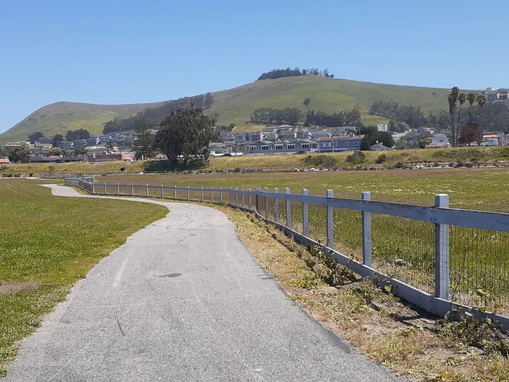 The path, with green hills. 