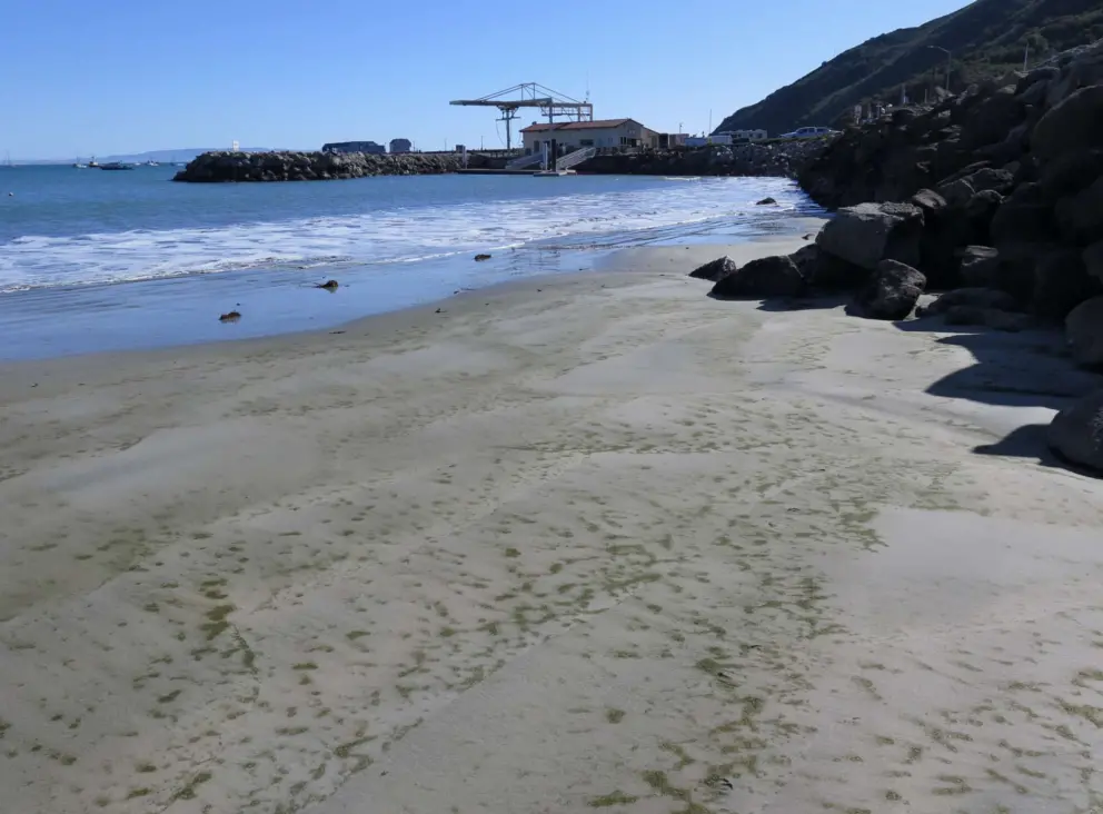 The sand gets dirtier as you near the harbor.