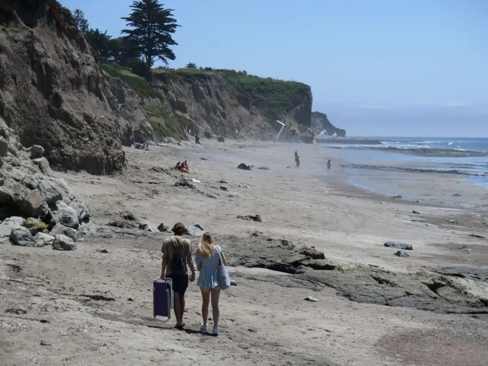 A young couple arriving at the beach. 