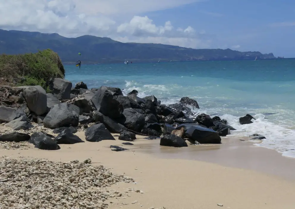 The mountains, black rocks, bright turquoise water, and pretty sand. 