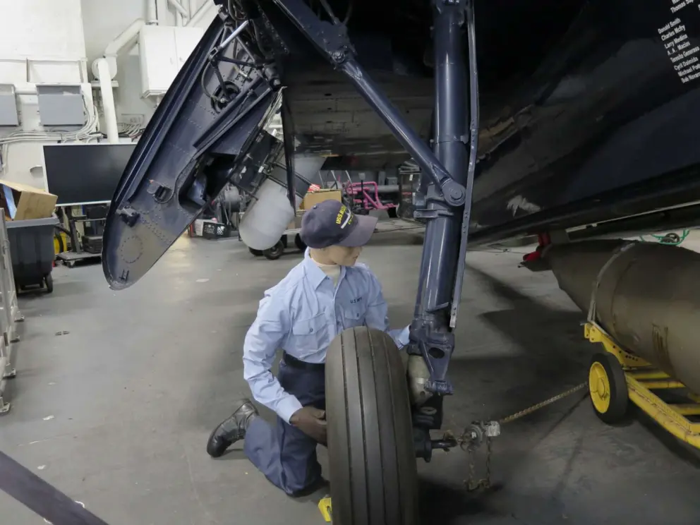 A mannequin of a technician working on the airplane. 