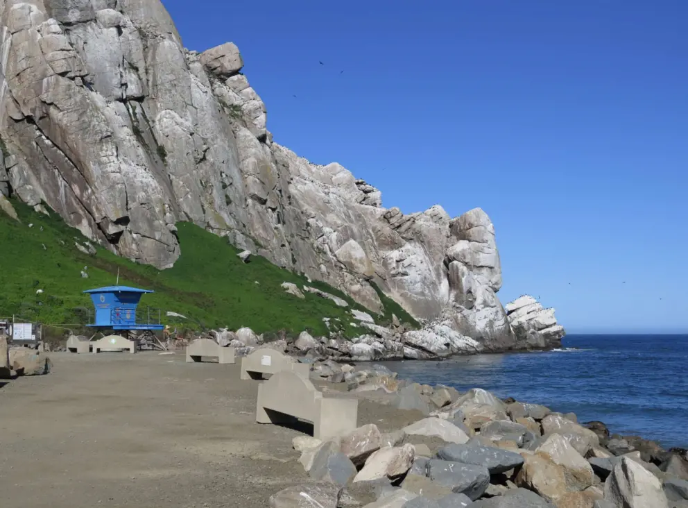 Strand with benches and the wonderful shapes of the rock at Morro Rock Beach. 