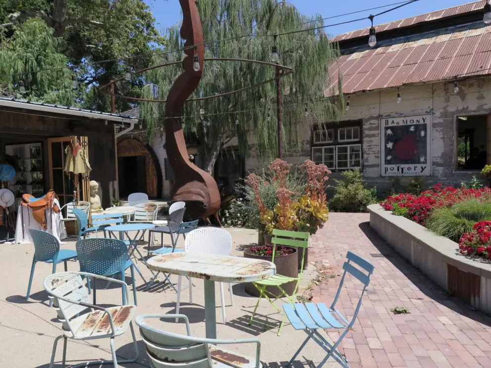 Seating outside the coffee shop, pottery store, and leather store. 