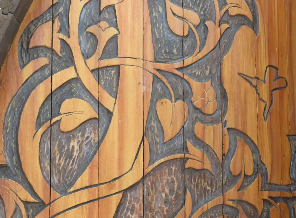 Hummingbird and leaves engraved on the chapel door. 