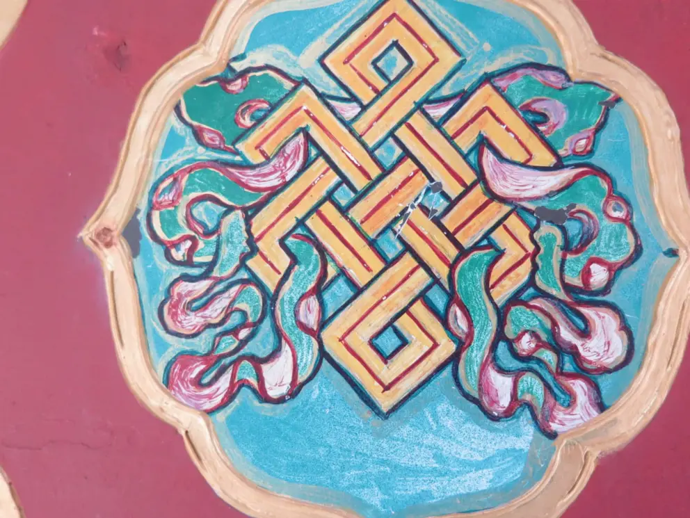 This prayer wheel design almost looks Celtic, because the eternal knot is in both traditions! It symbolizes interconnectedness and the eternal cycle of life. 
