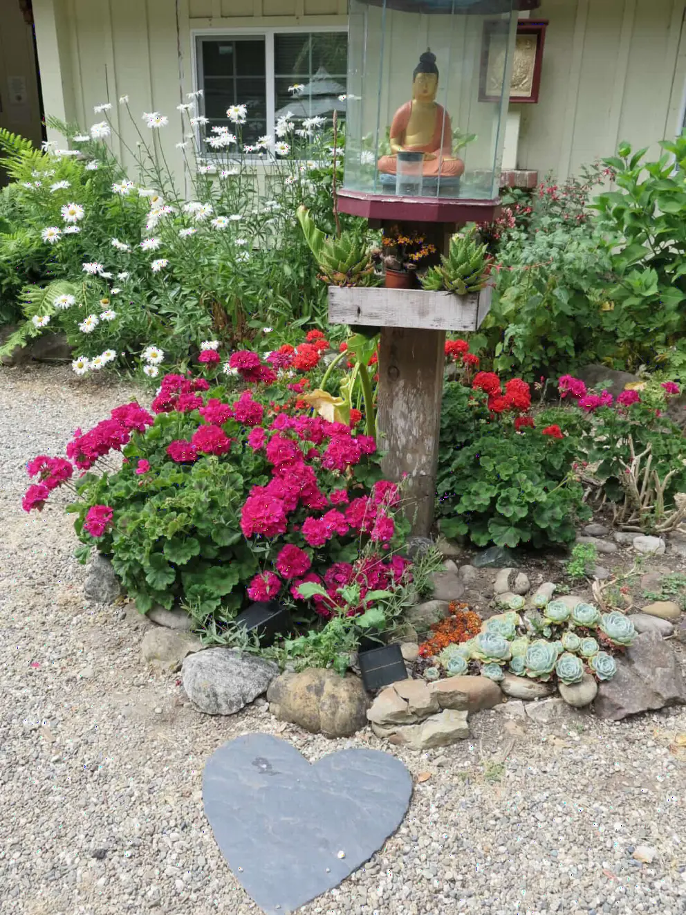 A heart-shaped stepping stone in front of a statue. 