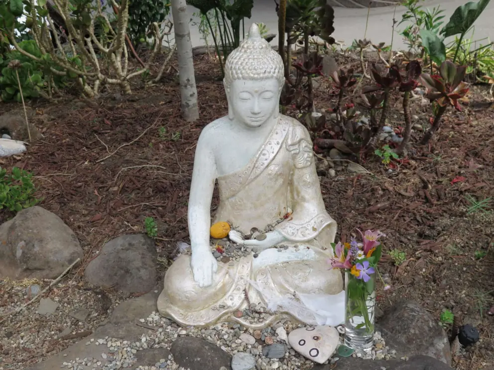 A delicate statue with offerings, by the gift shop. 